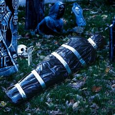 there are many halloween decorations on the ground in front of some tombstones and trees