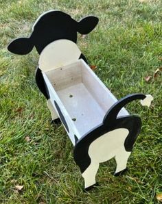 a cow shaped box sitting in the grass