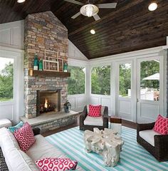 a living room with a fire place and couches in front of a stone fireplace