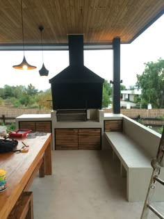 a large outdoor kitchen with an oven and counter tops on the outside side of the house