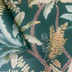 a green wallpaper with leaves and plants on it