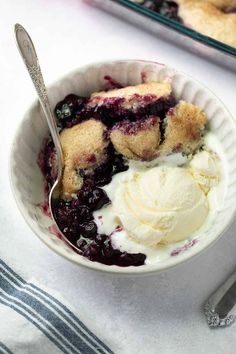 a bowl filled with ice cream and blueberry cobbler