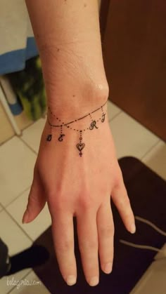 a woman's hand with a small tattoo on the middle of her left wrist