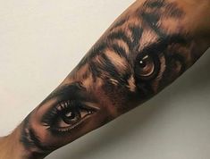 a tiger's eye is shown on the forearm and arm, while it appears to be painted with black ink