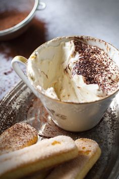 a cup of ice cream and some cookies on a plate