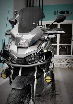 a motorcycle parked in front of a building with no one on it's seat