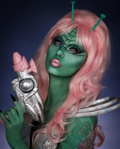 This stunning alien makeup look is sure to turn heads. The green face paint paired with a bright pink wig creates a striking contrast that’s both otherworldly and captivating. The intricate designs on the forehead add a cool sci-fi element, making this look truly unique.   Photo credit by: @marioncameleon 31 Days Halloween Makeup, Halloween Costumes Body Painting, Unique Alien Costume, Teal Alien Makeup, Womens Alien Makeup, Unique Halloween Makeup Looks, Alien Makeup Green, Alien Aesthetic Makeup, Alien Halloween Costumes Women