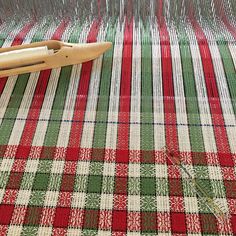 a pair of scissors sitting on top of a red and green checkered table cloth