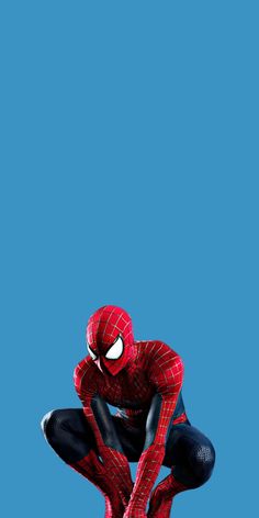 the amazing spider - man is standing on his knees in front of a blue background