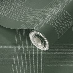 a green wallpaper with white lines on the bottom, and a roll of tape