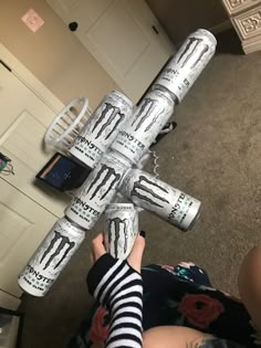 a person is holding up an upside down cross made out of toilet paper and duct tape