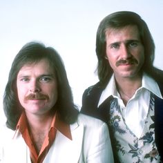 two men with long hair and moustaches posing for the camera