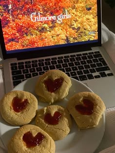 four cookies on a plate next to a laptop