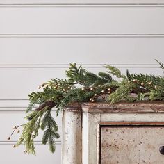 an old dresser with christmas greenery on top