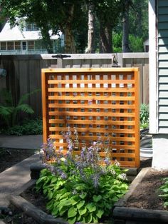 a wooden fence surrounded by plants and flowers