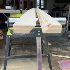 a piece of wood sitting on top of a table next to a sawing machine