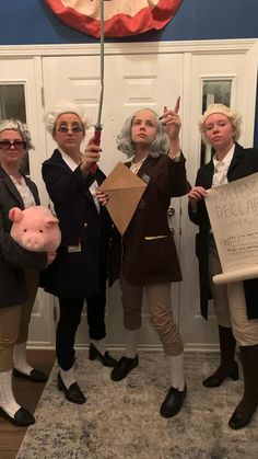 three women holding up signs in front of a white door with an american flag on it