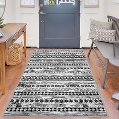 a black and white rug in front of a blue door