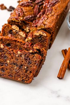 a loaf of pecan nut bread next to cinnamon sticks