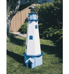 a blue and white lighthouse in the grass