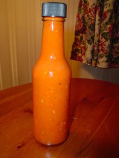 an orange bottle sitting on top of a wooden table