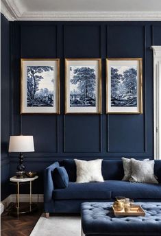 a living room with dark blue walls and white carpeted flooring, artwork on the wall