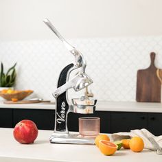 a kitchen counter with fruit, juicer and utensils on top of it