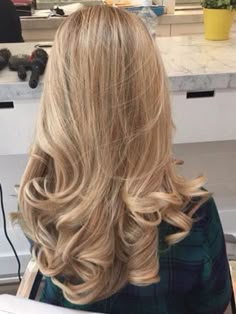 the back of a woman's head with long blonde hair in a beauty salon