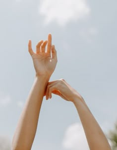 two hands reaching up into the sky