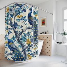 a shower curtain with blue and yellow peacocks on it next to a bathtub