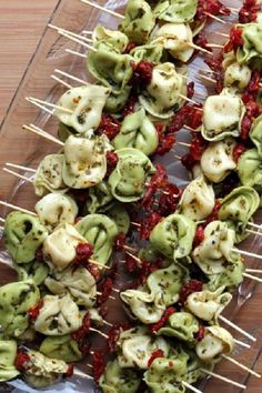 several skewers filled with food on top of a wooden table