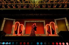 a man and woman standing on top of a stage