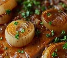 some onions are being cooked in a skillet with gravy and parsley