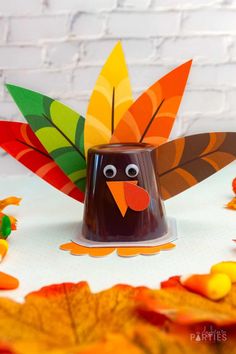 a paper turkey sitting on top of a table next to some candy cornucons