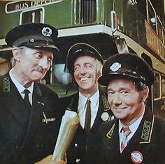 three men in uniform standing next to each other with a train on the back ground