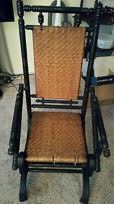 an old wooden chair with wicker seat and backrest, on carpeted floor