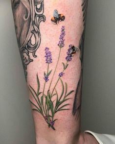 a woman's leg with lavenders and butterflies on it, in front of a mirror