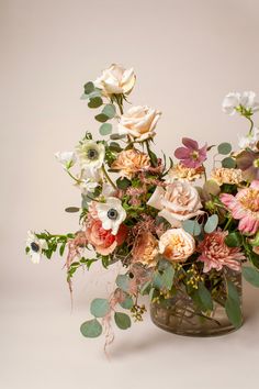 a vase filled with lots of flowers on top of a table