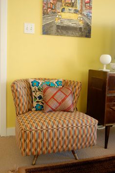 a living room filled with furniture and a painting on the wall