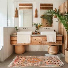 a bathroom with two sinks, mirror and rug on the floor in front of it