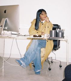 a woman sitting at a desk in front of a computer