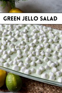 green jello salad with lemons and limes in the background, on a wicker place mat