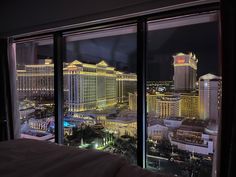 a hotel room with a view of the las vegas strip and casino buildings at night