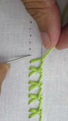 someone is working on something that looks like a crochet stitching pattern with green yarn