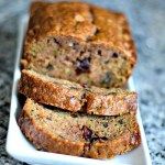 sliced loaf of fruit and nut bread on a white plate