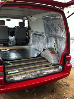 the back end of a red van with its doors open