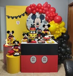 a mickey mouse birthday party with balloons and decorations