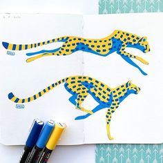 two blue and yellow cheetah drawings on a white paper next to marker pens