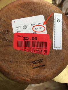 a close up of a price label on a piece of wood with a barcode