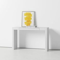 a white table with a yellow painting on it's shelf next to a wall